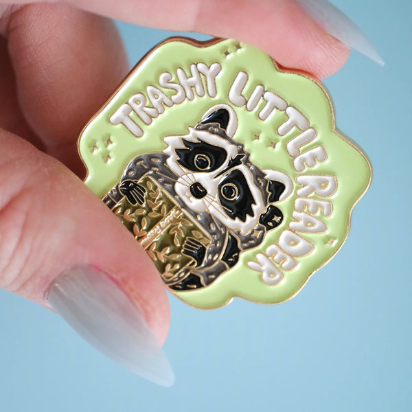 611fc05e3c4ce80992caae23_trashy-little-reader-racoon-pin_1790864758951.jpg